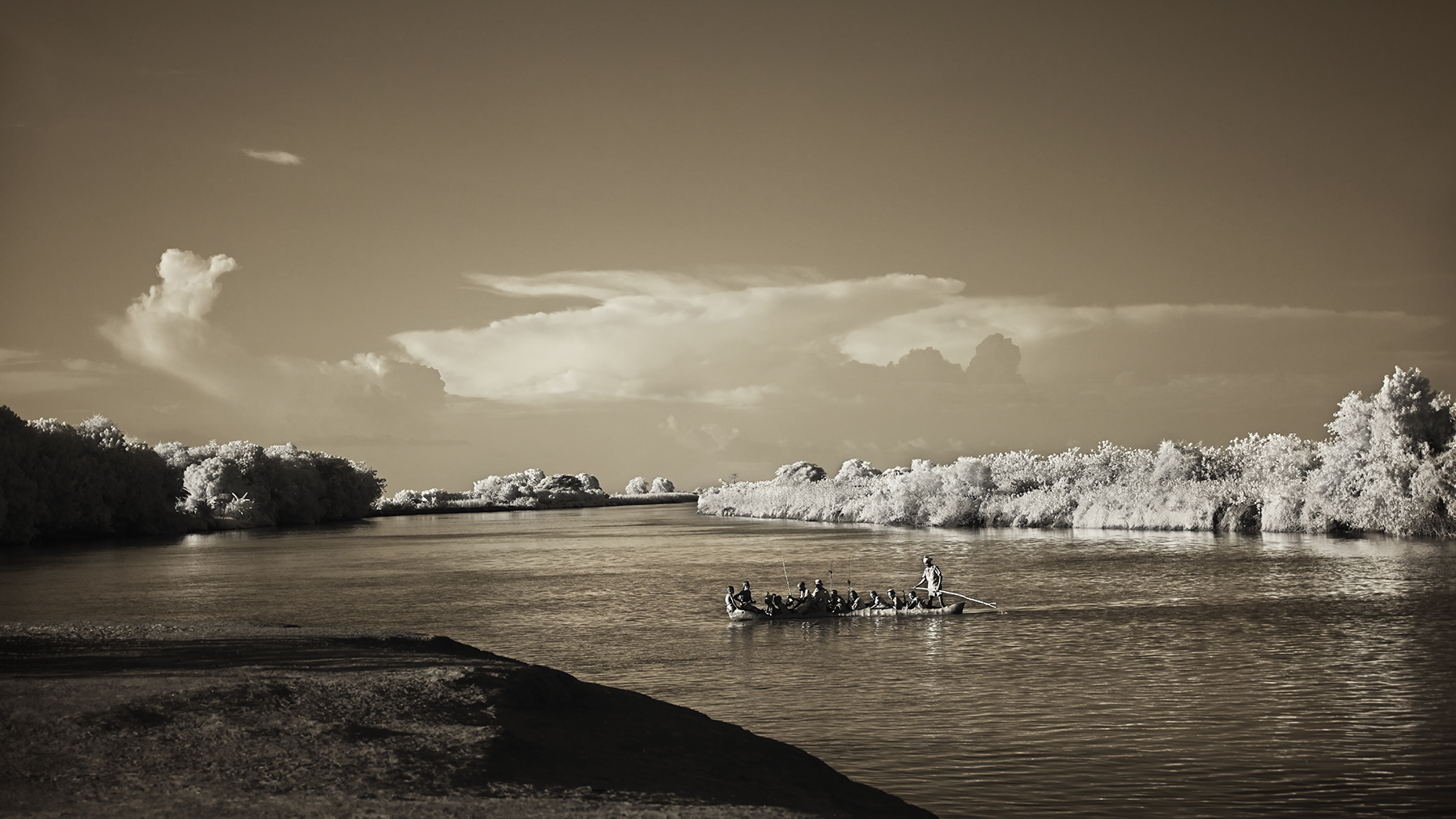 Fine art print of tribal people crossing the Omo River by canoe in Ethiopia